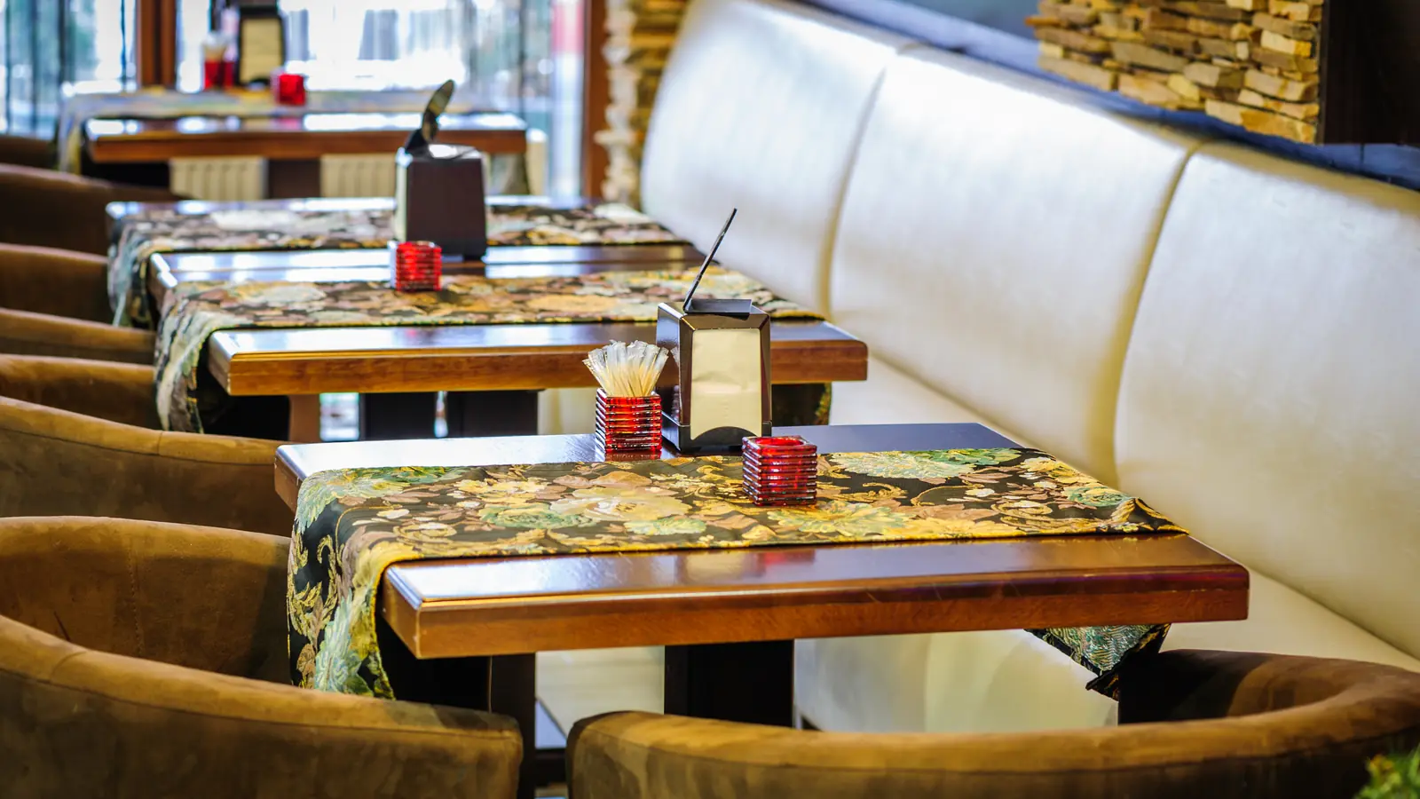 Stilvoll eingerichtetes Restaurant-Interior mit gedeckten Tischen und warmer Atmosphäre — sinnbildlich für eine Gastro-Website, die Atmosphäre transportiert und Reservierungen generiert