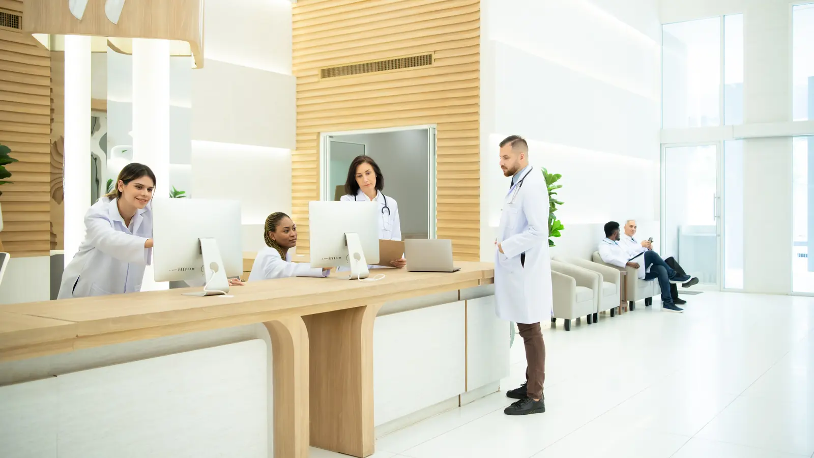 Ärzteteam im Krankenhaus im Gespräch — sinnbildlich für eine vertrauenswürdige Praxis-Website mit Team-Profilen, Online-Termin und klarer Patienteninformation