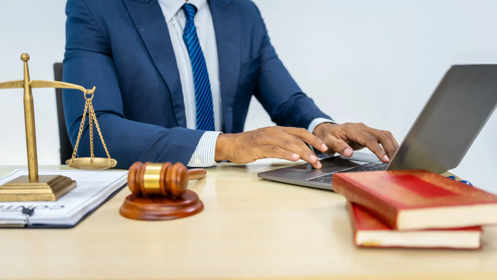 Anwalt im blauen Anzug arbeitet konzentriert am Laptop — sinnbildlich für eine professionelle, vertrauenswürdige Kanzlei-Website 2026